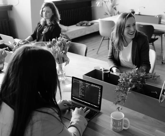 A group of 3 women working on their computers